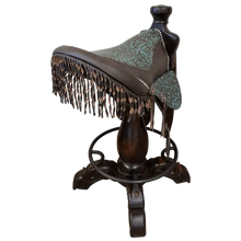 Load image into Gallery viewer, The Mustang Saddle Barstool features embossed turquoise leather, full-grain leather panels, and a hand-forged medallion on a 180° swivel wood base. A handcrafted Western saddle barstool celebrating the artistry and heritage of the American West.