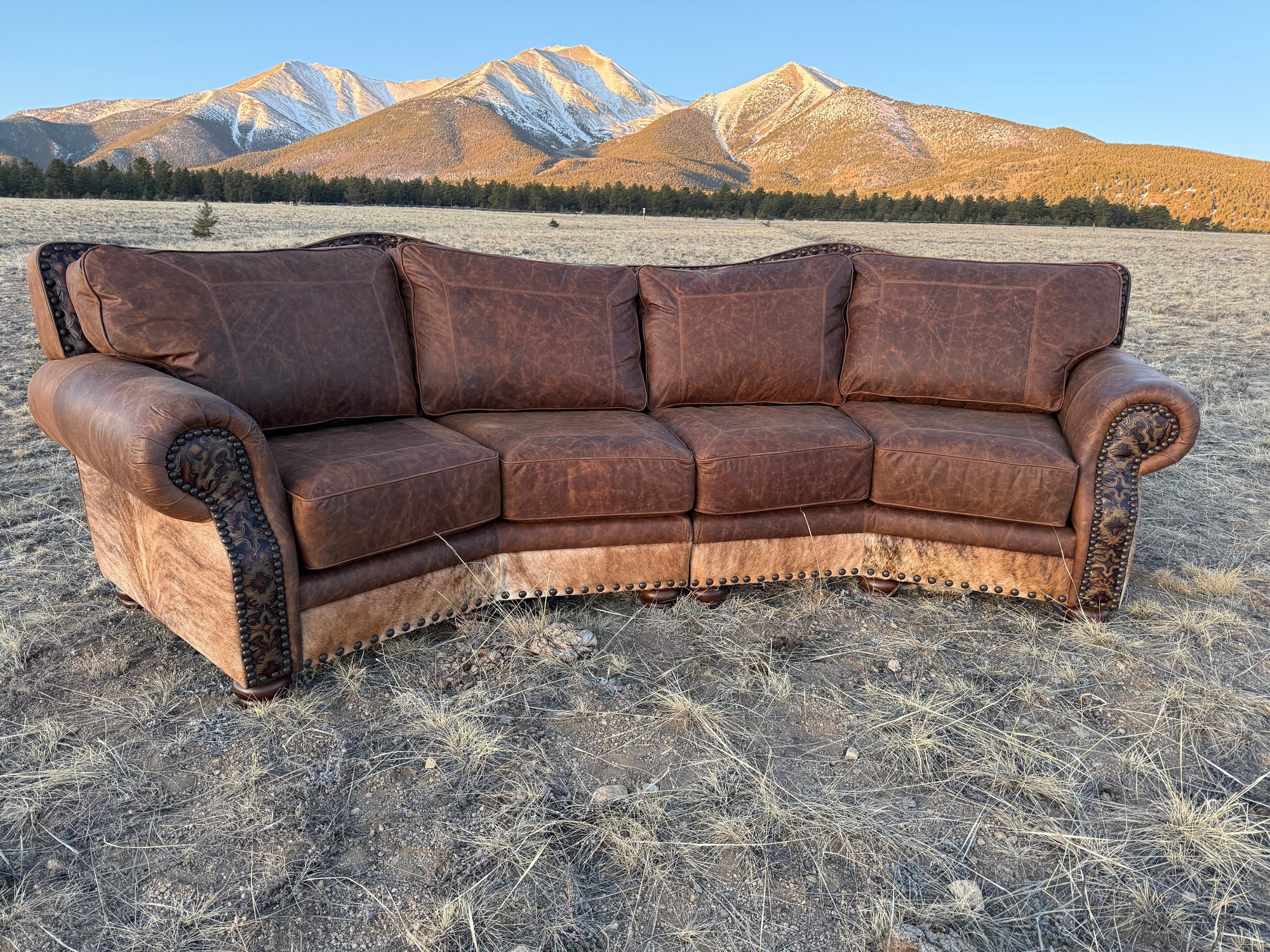 Ranchero Western Leather & Cowhide Curved Sectional Sofa Lifestyle Shot With Mountain Background