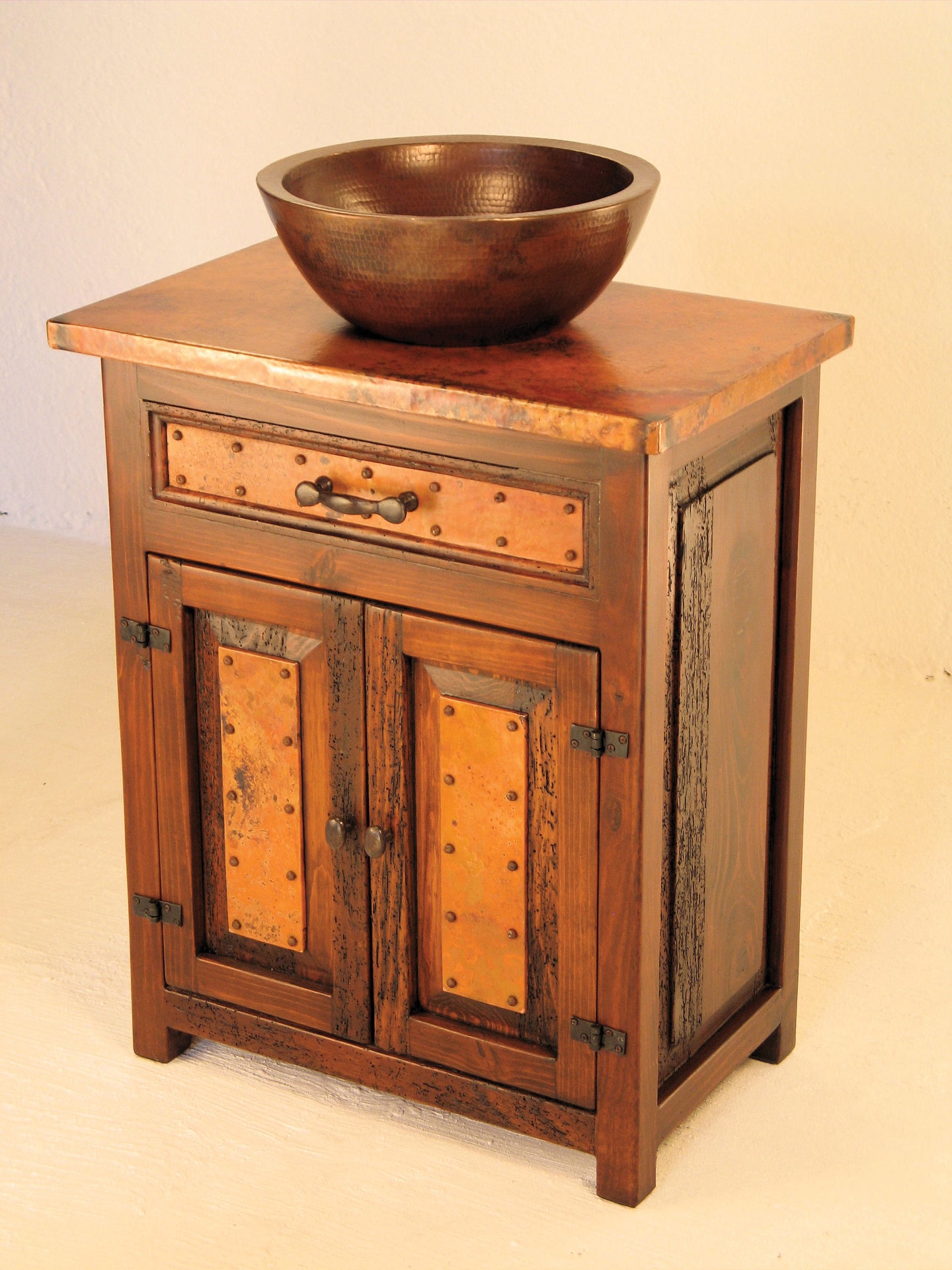 Add rustic charm to your bathroom with the Deer Valley Sink Cabinet, featuring copper accents & storage cabinets.