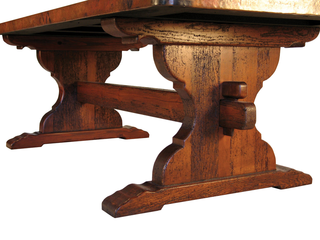 Discover the Trestle Copper Dining Table, featuring a handcrafted wood trestle base and a hammered copper top. Available in multiple sizes with custom options for a perfect fit.