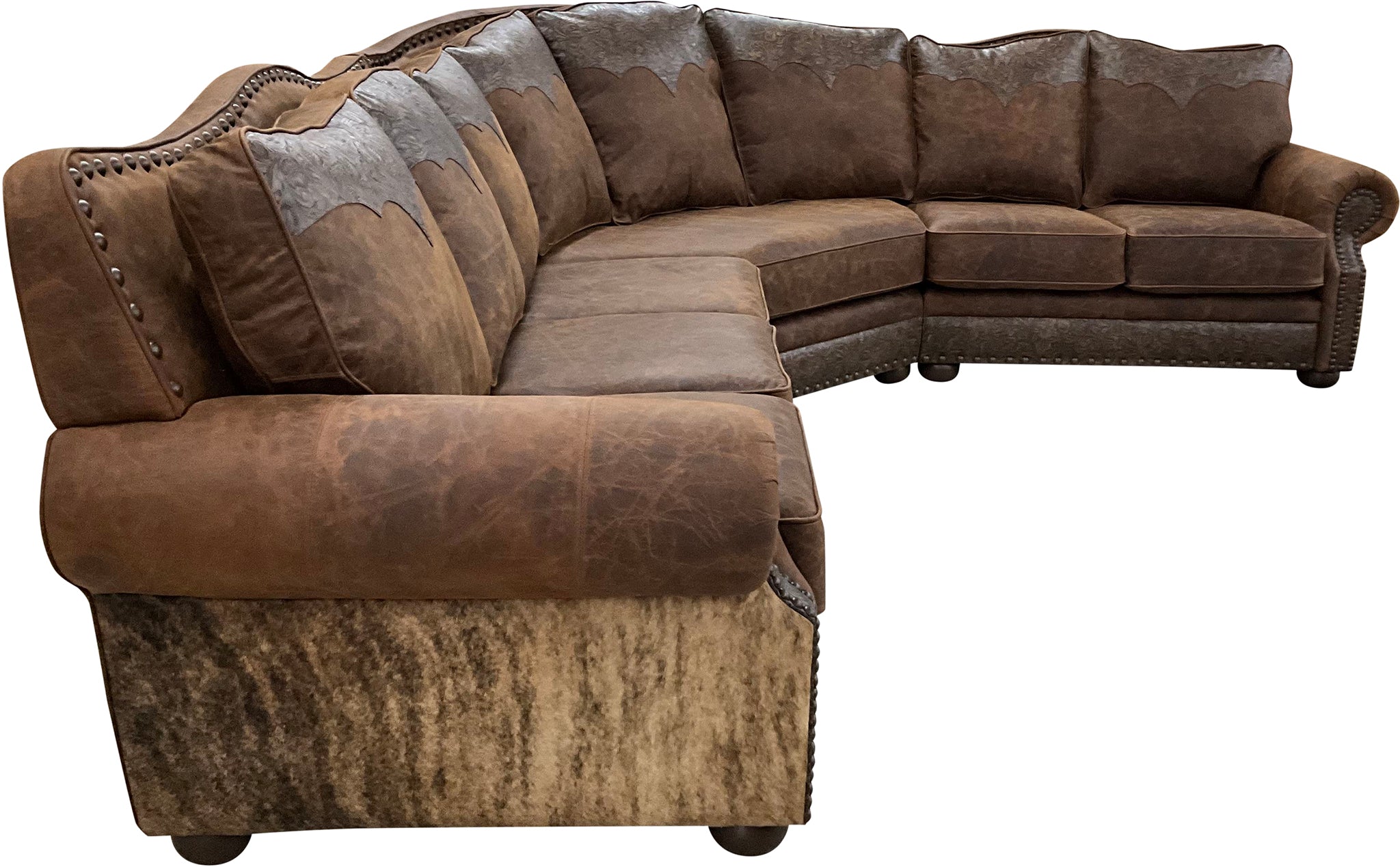 The Sandpoint Sectional features Cora Pecan leather, Floral Bone Black accents, and Hair-on-Hide Dark Exotic cowhide. With a large three-cushion pie piece and three-point yoke back cushions, this Western sectional offers luxury, comfort, and bold style.