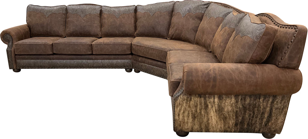The Sandpoint Sectional features Cora Pecan leather, Floral Bone Black accents, and Hair-on-Hide Dark Exotic cowhide. With a large three-cushion pie piece and three-point yoke back cushions, this Western sectional offers luxury, comfort, and bold style.