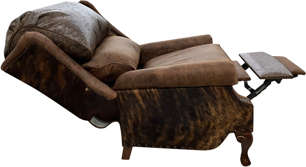 The Sandpoint Recliner combines Cora Pecan leather, Floral Bone Black embossed accents, and Hair-on-Hide Dark Exotic cowhide. A handcrafted Western-style recliner with classic wingback design, double bustleback cushions, and classic nailhead trim.