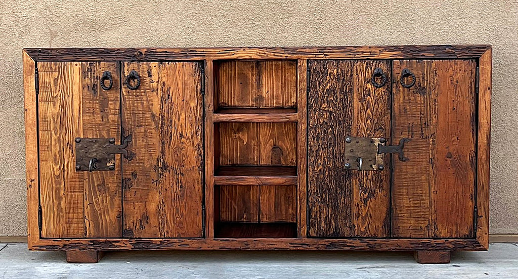old world credenza Rustic wooden cabinet with metal handles against a beige wall.