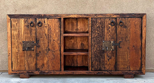 old world credenza Rustic wooden cabinet with metal handles against a beige wall.