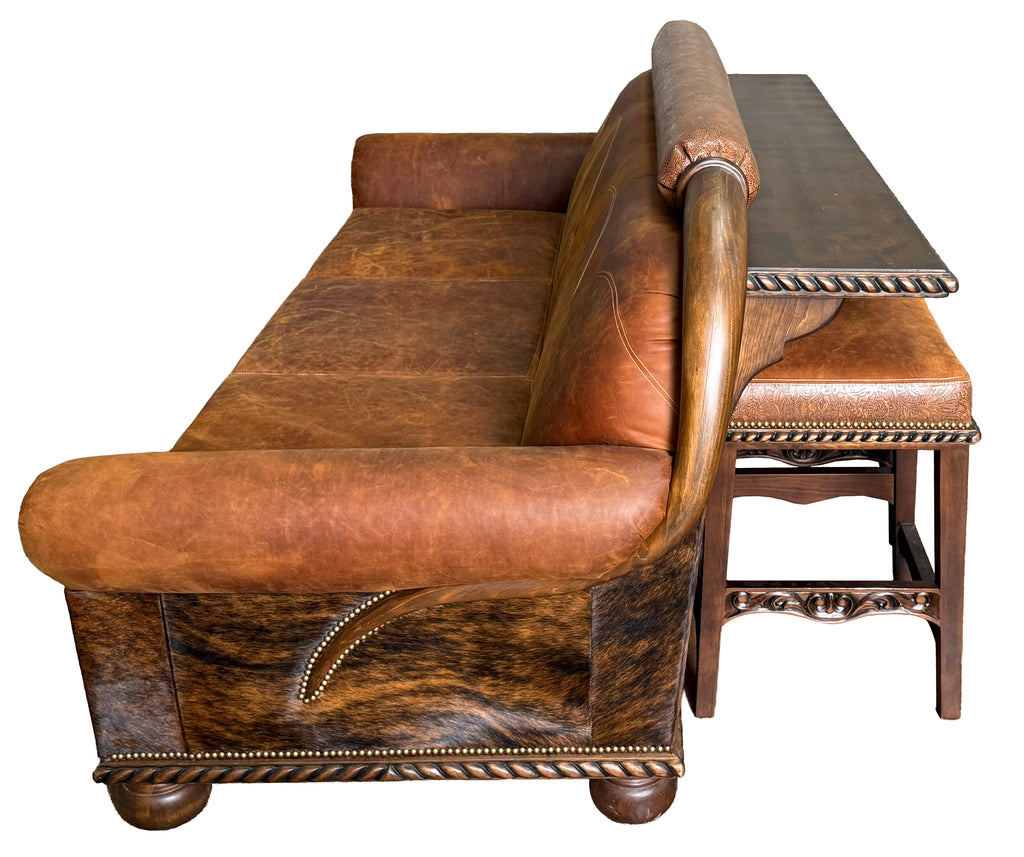 Brown leather sofa with decorative armrests on a white background