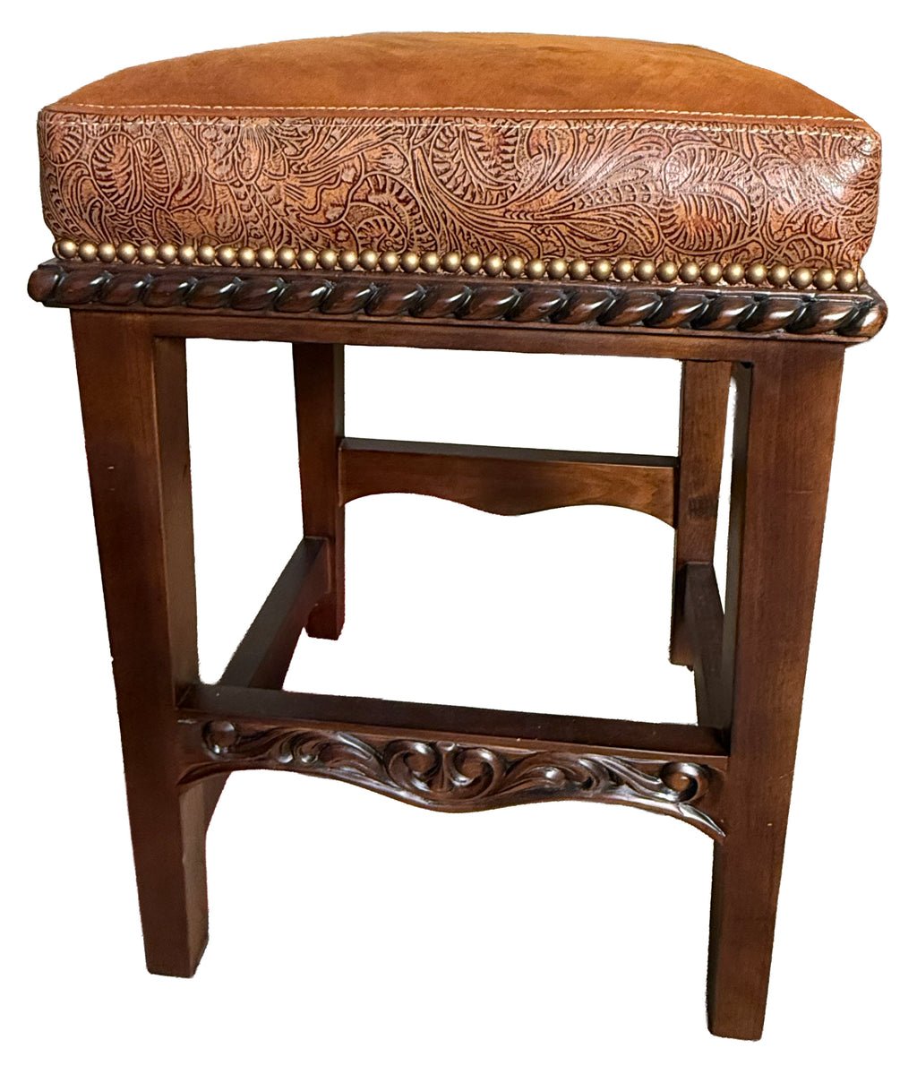 Brown leather stool with intricate patterns on a white background