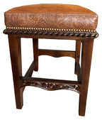 Brown leather stool with intricate patterns on a white background