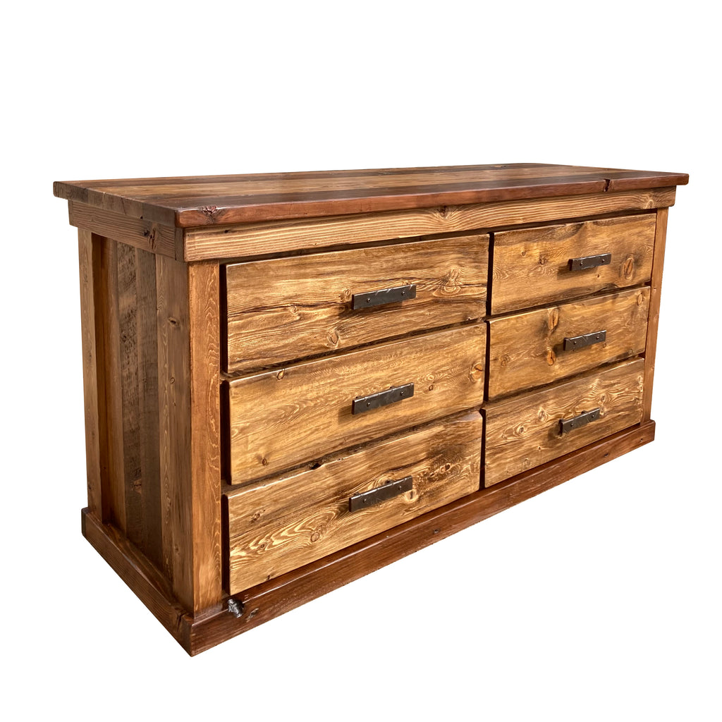 A rustic lowboy dresser made of ponderosa pine with hand forged iron pulls against a white backdrop.