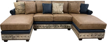 Load image into Gallery viewer, The High Plains Sectional features Palio Camel leather, Palio Grey accent trim, and light exotic cowhide for a modern western luxury statement. Oversized comfort, deep chaise seating, hand applied nailheads, and fully customizable ranch estate craftsmanship.