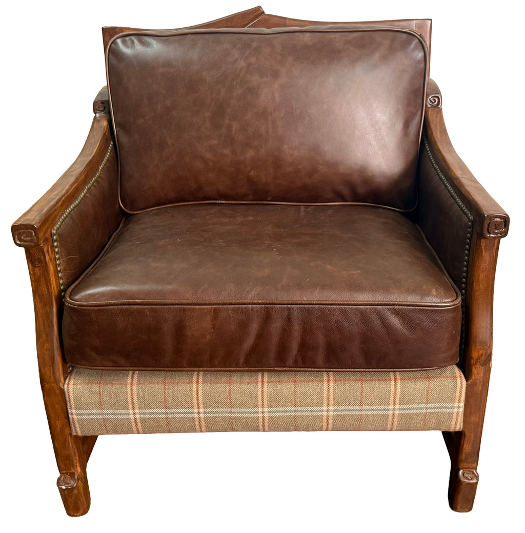 Brown leather armchair with plaid patterned base on a white background