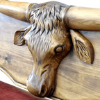 Handcrafted Western bench with longhorn carving, red leather seat, and “Cowboys” inscription. The Cowboy Bench combines rustic artistry with bold, personalized craftsmanship.