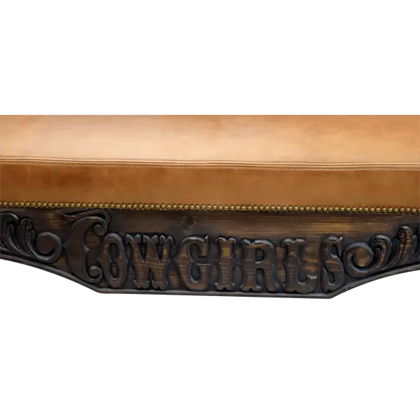 Handcrafted Western bench featuring saddle and lasso carvings, leather seat, and “Cowgirls” inscription. The Cowgirl Bench blends artistry, strength, and frontier elegance.