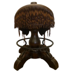 The Bronco Saddle Barstool features a handcrafted full-grain leather saddle seat with cowhide fenders, hand-forged iron medallion, and wood pedestal base. A 180° swivel Western barstool blending authentic cowboy craftsmanship with rustic luxury.