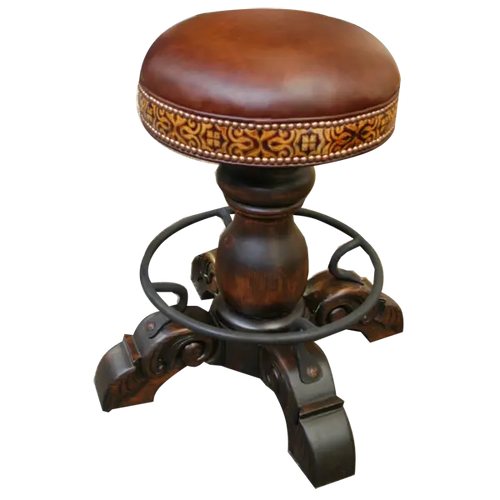 The El Matador Bajo 5 Barstool features brown full-grain leather, hand-tooled accents, and a carved wood base with a forged iron footrest. A 360° swivel and customizable design make it a perfect blend of comfort and craftsmanship.