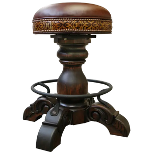 The El Matador Bajo 5 Barstool features brown full-grain leather, hand-tooled accents, and a carved wood base with a forged iron footrest. A 360° swivel and customizable design make it a perfect blend of comfort and craftsmanship.