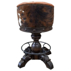 The Rocca La Elegante 2 Barstool features rich brown leather, hand-carved wood, and forged iron details. With a tufted back, 180° swivel, and bold Western style, it’s elegance with rugged sophistication.