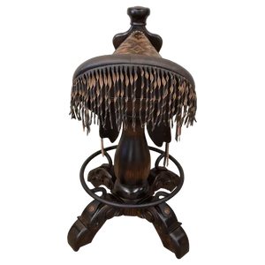 The Chaps Saddle Barstool features full-grain leather, embossed Western patterns, copper conchos, and a 180° swivel wooden base. A handcrafted Western saddle barstool that celebrates cowboy craftsmanship and the artistry of the American frontier.