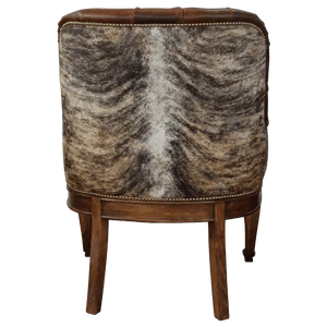 The La Antigua 6 Chair features hand-carved scroll details, tufted full-grain leather, and a sturdy wood frame. Precision hand-tacked upholstery and customizable finishes define this handcrafted Western-style accent chair.