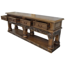 Load image into Gallery viewer, Handcrafted Spanish colonial console with baroque floral scroll carvings, forged iron handles, 4 drawers, platform base &amp; antique finish. Customize your luxury Western décor piece.