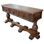 Handcrafted Spanish colonial console with carved scrollwork, twist rope details, forged iron pulls, turned pedestals, and customizable solid wood construction.