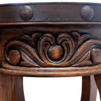 Handcrafted round end table with carved floral base, hammered copper rim, and iron conchos. The Drum End Table blends rustic artistry with refined Western craftsmanship.