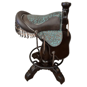The Mustang Saddle Barstool features embossed turquoise leather, full-grain leather panels, and a hand-forged medallion on a 180° swivel wood base. A handcrafted Western saddle barstool celebrating the artistry and heritage of the American West.