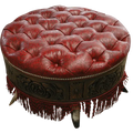 Handcrafted red leather ottoman with carved wood base, nailhead trim, and fringe detailing. The Coronado Ottoman blends Western luxury with timeless artisan craftsmanship.