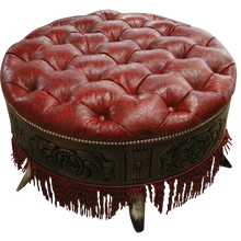 Load image into Gallery viewer, Handcrafted red leather ottoman with carved wood base, nailhead trim, and fringe detailing. The Coronado Ottoman blends Western luxury with timeless artisan craftsmanship.