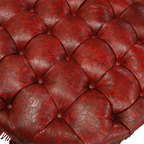 Handcrafted red leather ottoman with carved wood base, nailhead trim, and fringe detailing. The Coronado Ottoman blends Western luxury with timeless artisan craftsmanship.