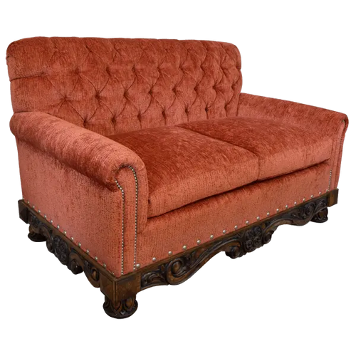 Handcrafted Western loveseat with carved wood base, rust-toned fabric, and tufted backrest. The Durango Loveseat blends rustic warmth with refined craftsmanship. Customizable.