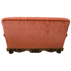 Handcrafted Western loveseat with carved wood base, rust-toned fabric, and tufted backrest. The Durango Loveseat blends rustic warmth with refined craftsmanship. Customizable.